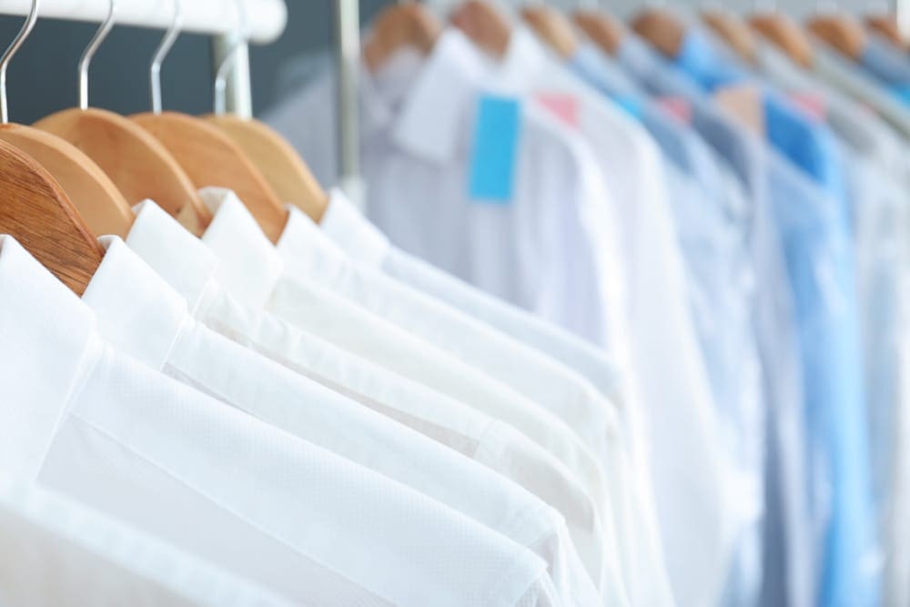 A woman ironing a shirt on an ironing board.