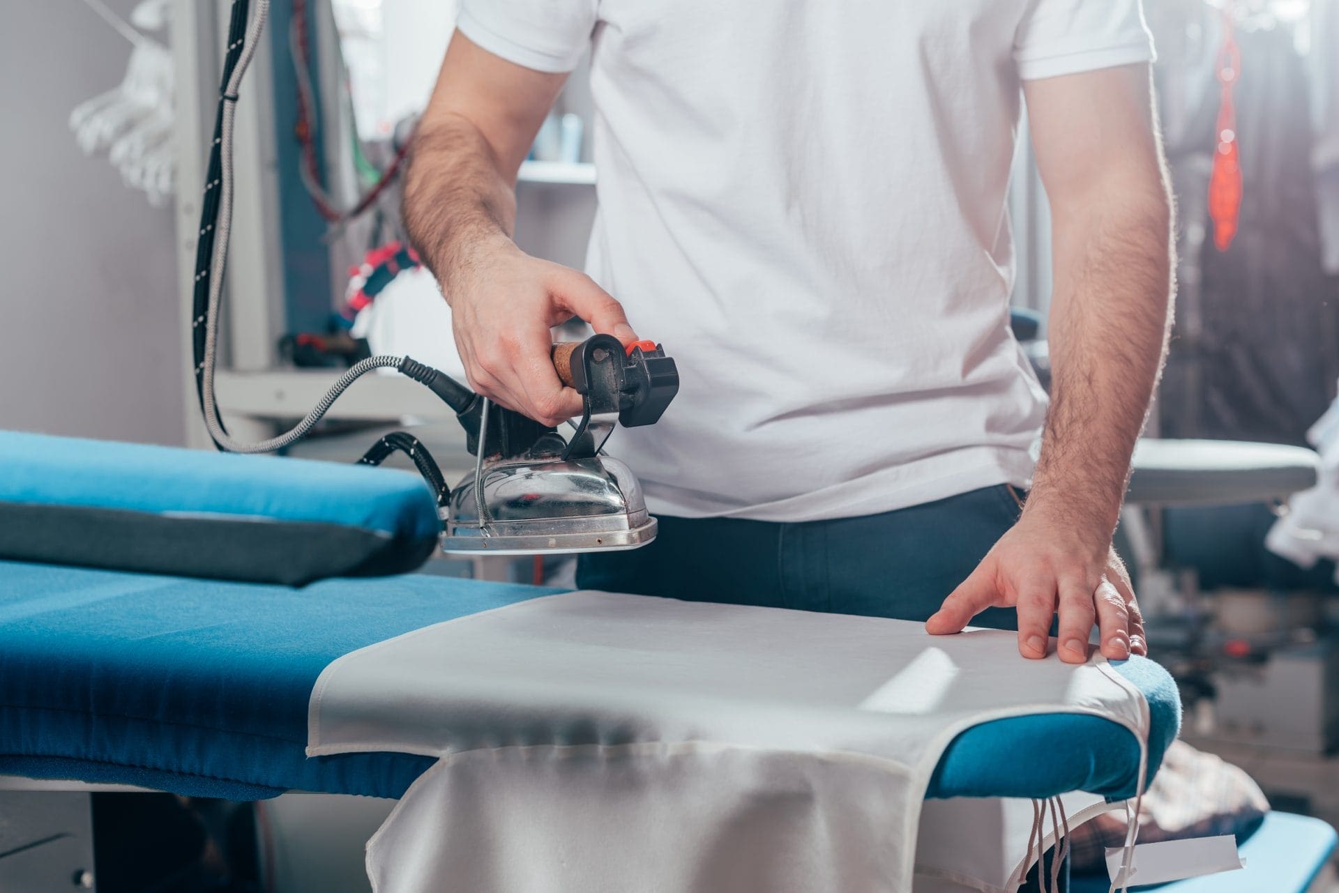 A woman ironing a shirt on an ironing board.